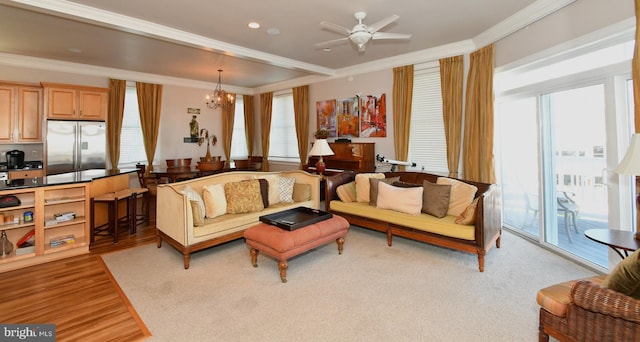 living room featuring recessed lighting, light wood-style flooring, ceiling fan with notable chandelier, and ornamental molding