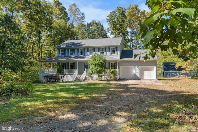 view of front of property featuring a garage, a front lawn, and covered porch