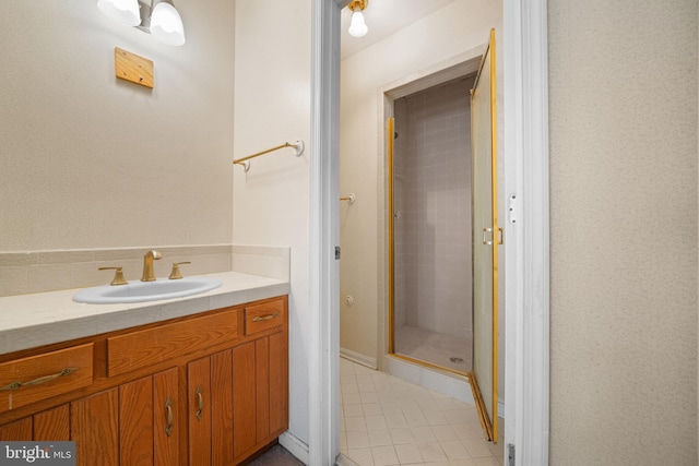 bathroom with tile patterned floors, a shower with door, and vanity