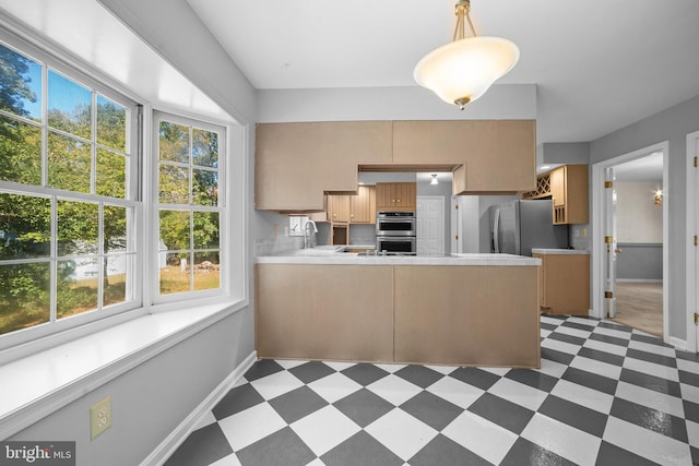 kitchen featuring appliances with stainless steel finishes, kitchen peninsula, and a healthy amount of sunlight