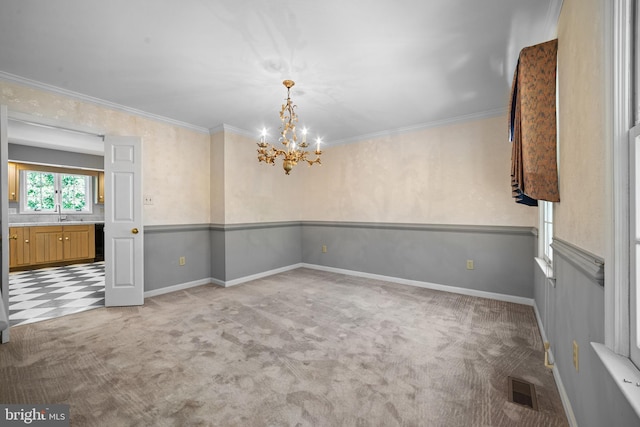 carpeted spare room featuring a notable chandelier, crown molding, and sink