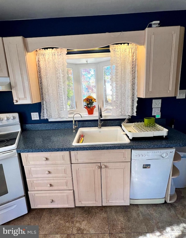 kitchen featuring range hood, white cabinetry, dark tile patterned flooring, sink, and white appliances