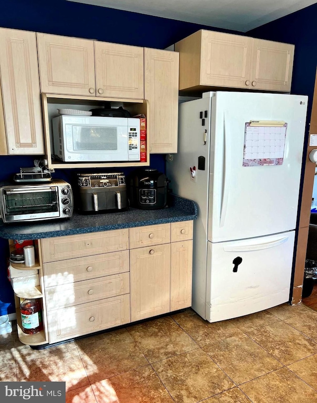 kitchen featuring white appliances and tile patterned flooring