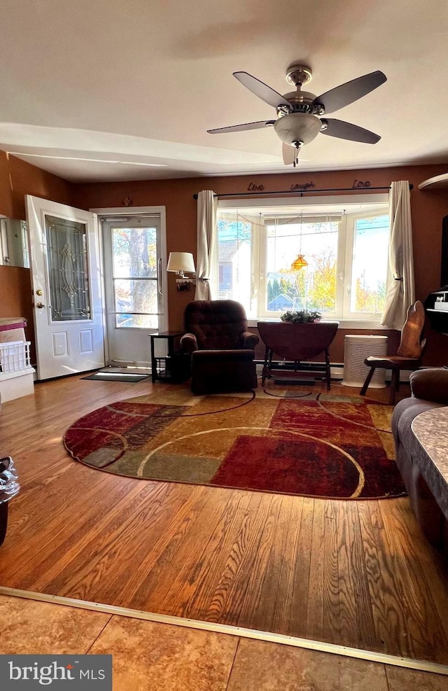 living room featuring a wealth of natural light, wood-type flooring, and ceiling fan