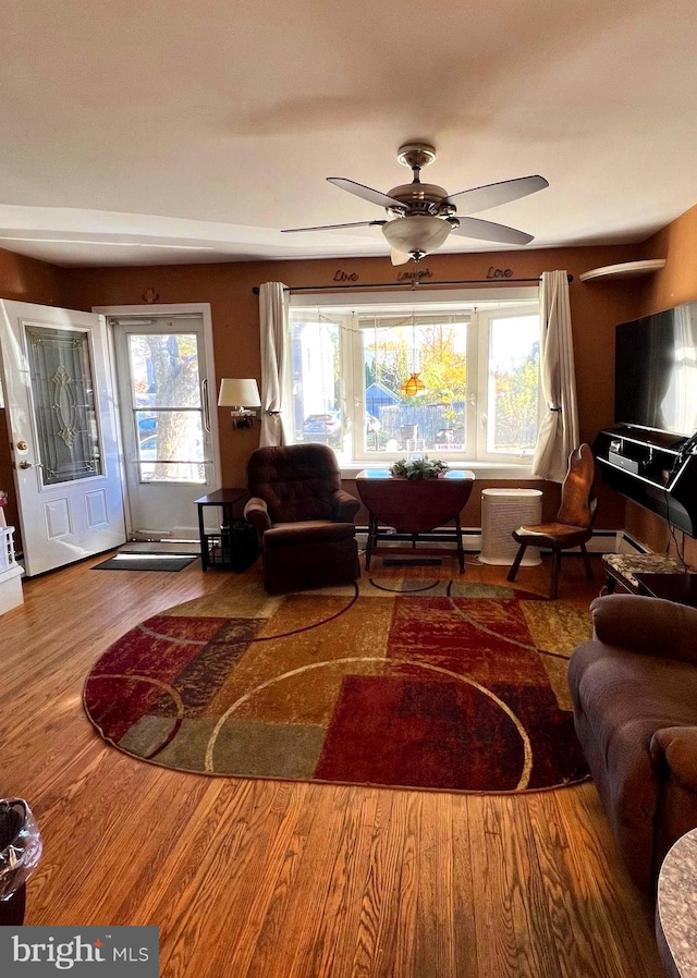 living room featuring ceiling fan, wood-type flooring, and plenty of natural light