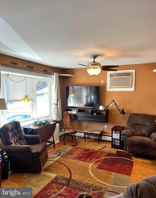 living room with a wall mounted air conditioner, wood-type flooring, and ceiling fan