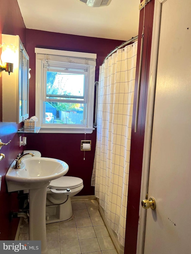 bathroom with toilet, a shower with curtain, and tile patterned floors