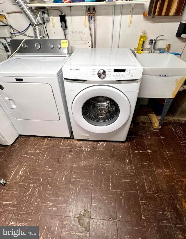 clothes washing area featuring sink and washing machine and clothes dryer