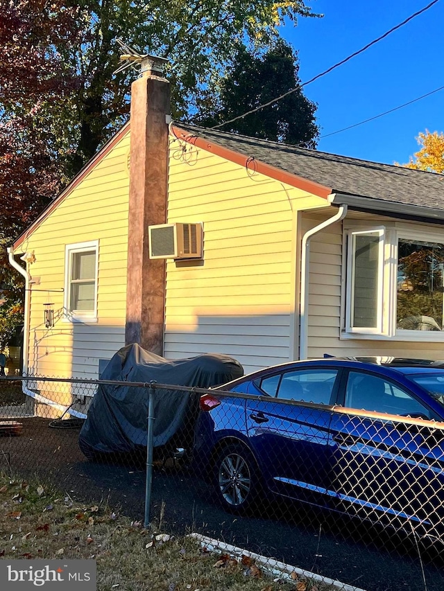 view of side of home featuring an AC wall unit