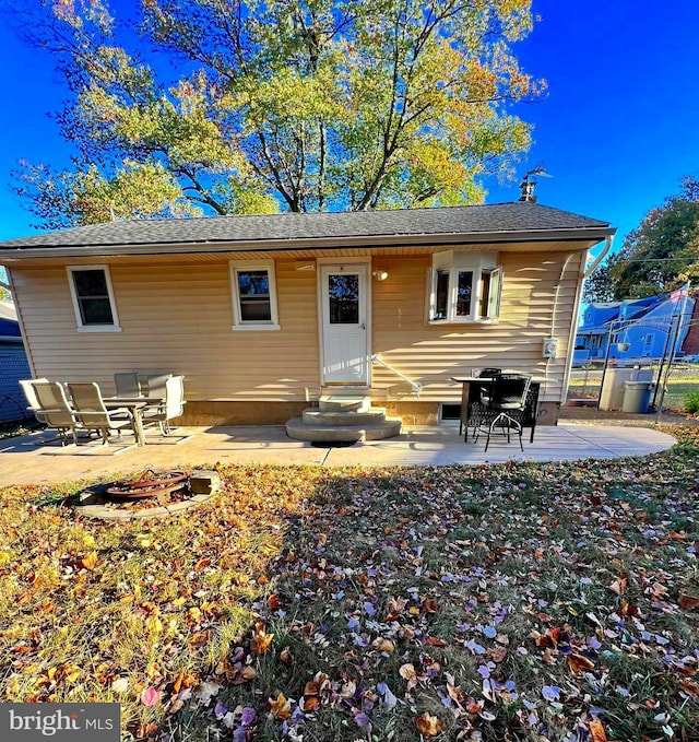 back of property featuring a patio area and a fire pit