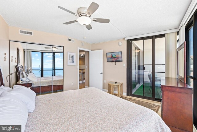 bedroom featuring a textured ceiling, access to outside, and ceiling fan