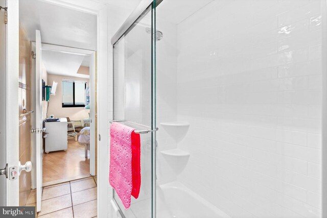 bathroom featuring tile patterned floors and shower / bath combination with glass door