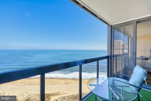 balcony featuring a water view and a view of the beach