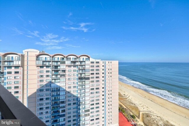 view of building exterior with a water view and a beach view