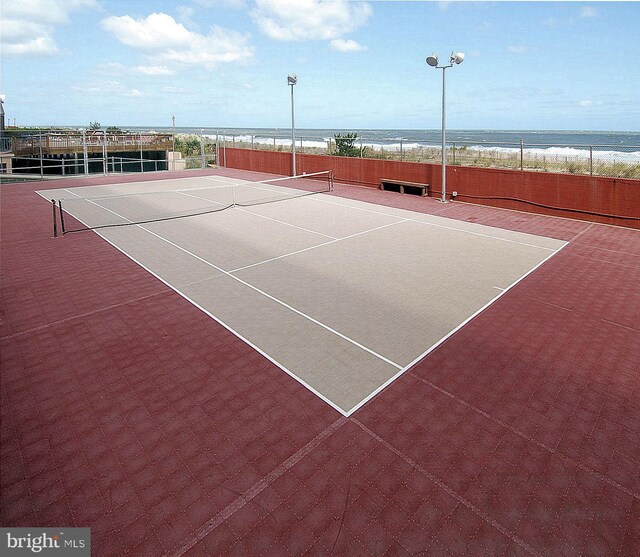 view of tennis court with a water view and basketball hoop