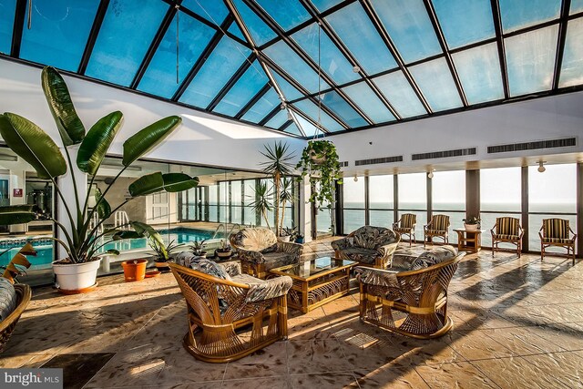 sunroom / solarium featuring a swimming pool, a water view, and a skylight