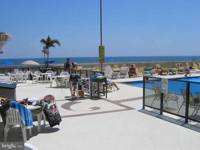 view of patio featuring a community pool and a water view