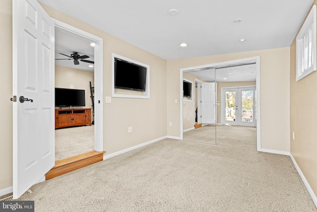 unfurnished living room featuring carpet flooring, ceiling fan, baseboards, recessed lighting, and french doors