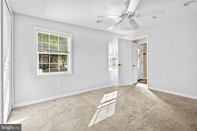unfurnished bedroom featuring carpet, baseboards, and multiple windows