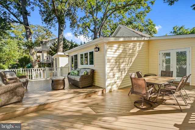 wooden deck with outdoor dining space and french doors