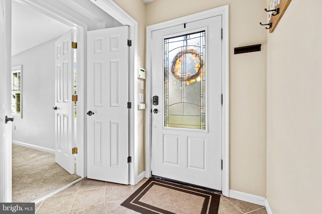 entrance foyer featuring light tile patterned flooring, a healthy amount of sunlight, and baseboards