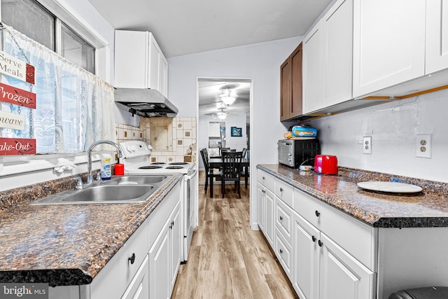 kitchen with tasteful backsplash, white cabinets, sink, vaulted ceiling, and electric stove