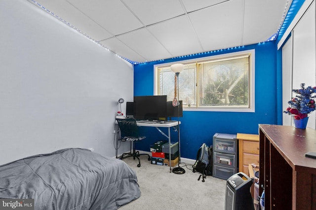 carpeted bedroom featuring a drop ceiling