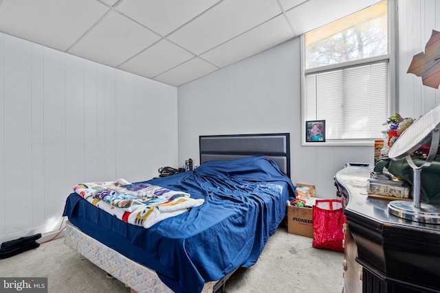 carpeted bedroom featuring a drop ceiling