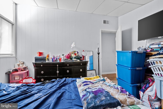 bedroom featuring wood-type flooring and wooden walls