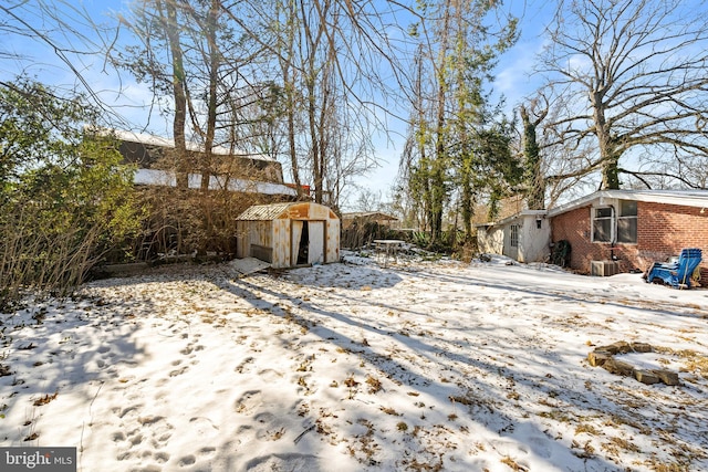 snowy yard with a storage shed