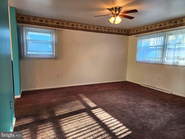 unfurnished room with a baseboard radiator, a wealth of natural light, ceiling fan, and dark colored carpet