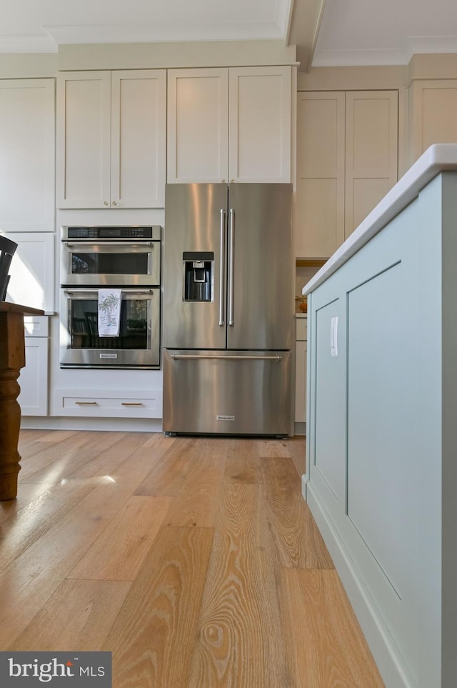 kitchen featuring white cabinetry, stainless steel appliances, and light wood-type flooring