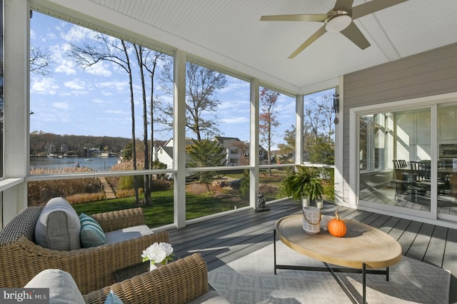 sunroom featuring a water view and ceiling fan