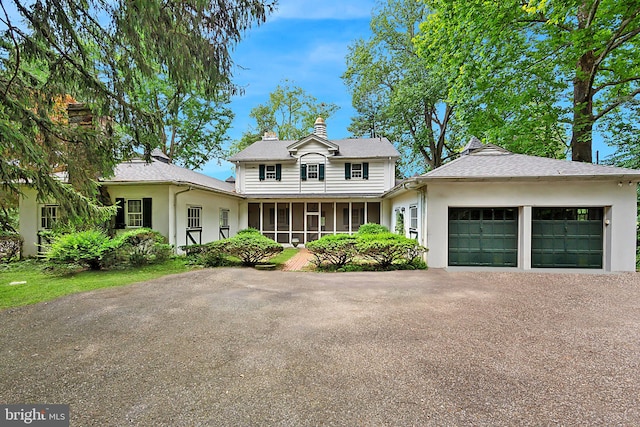 view of front of house featuring a garage and a sunroom