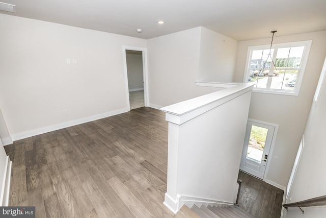 foyer with a notable chandelier, plenty of natural light, and wood-type flooring