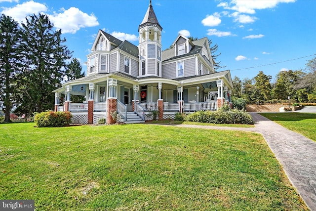 victorian-style house featuring covered porch and a front lawn