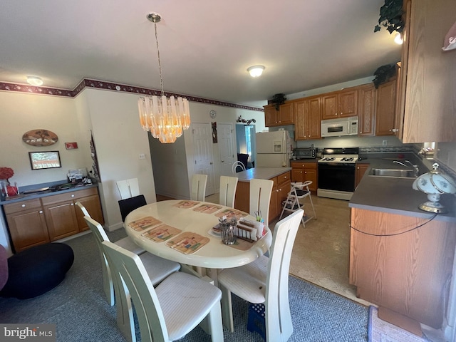 dining room featuring a chandelier, light tile patterned floors, and sink