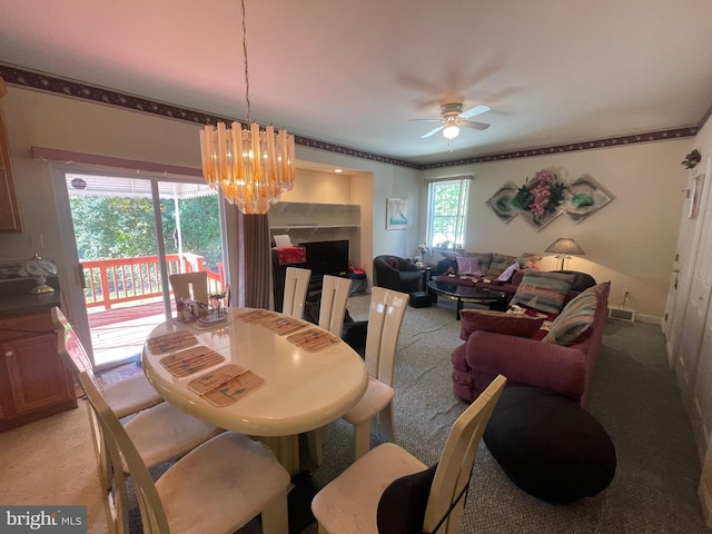 dining area featuring ceiling fan with notable chandelier