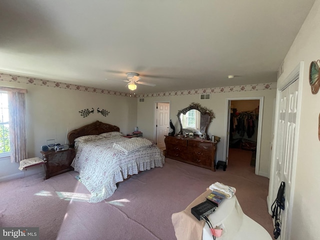 carpeted bedroom featuring a closet, a spacious closet, and ceiling fan