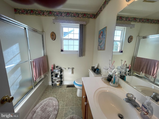 full bathroom featuring shower / bath combination with glass door, vanity, and toilet