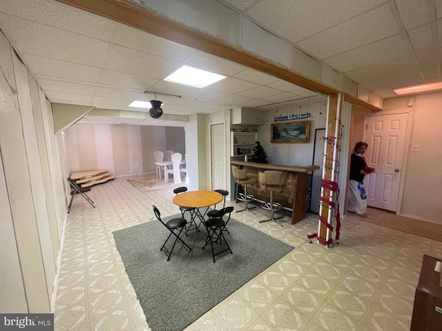 dining room featuring bar area and a paneled ceiling