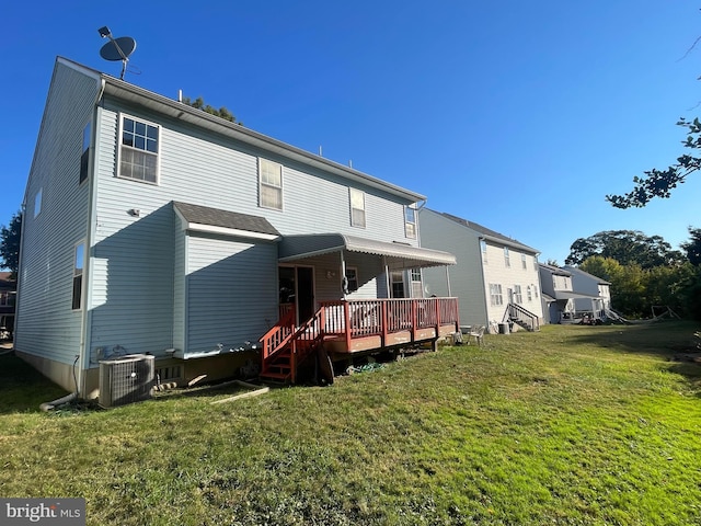 rear view of property featuring a yard, a deck, and central AC unit