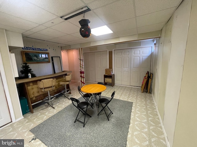 dining area with a drop ceiling and bar