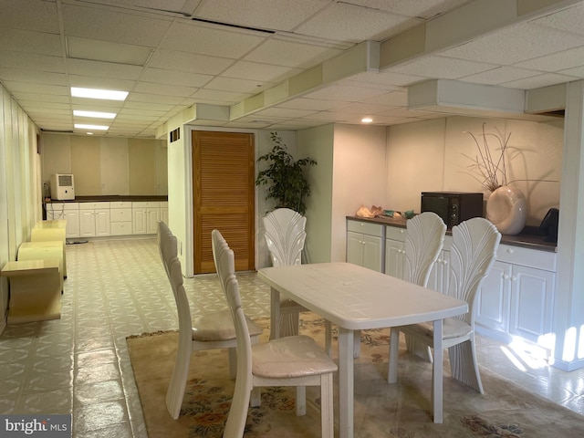 dining space featuring a drop ceiling