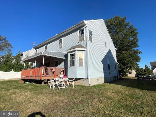 rear view of house featuring a lawn and a wooden deck