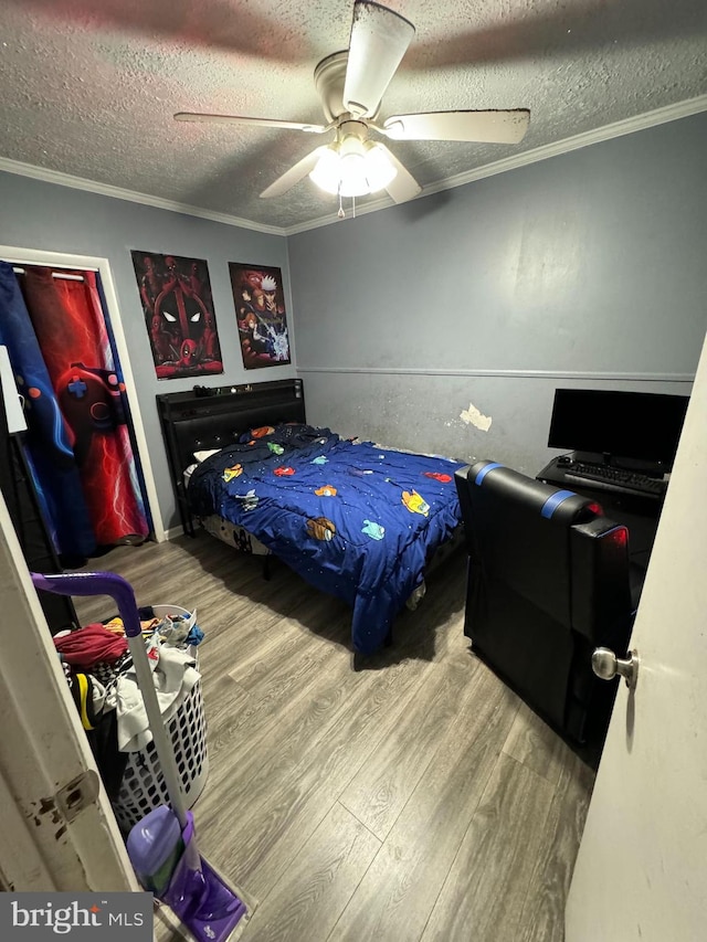 bedroom with hardwood / wood-style floors, crown molding, a textured ceiling, and ceiling fan