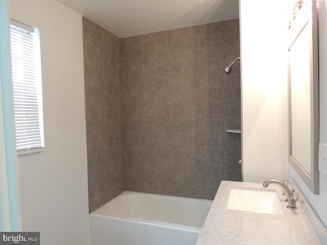 bathroom with tiled shower / bath and vanity