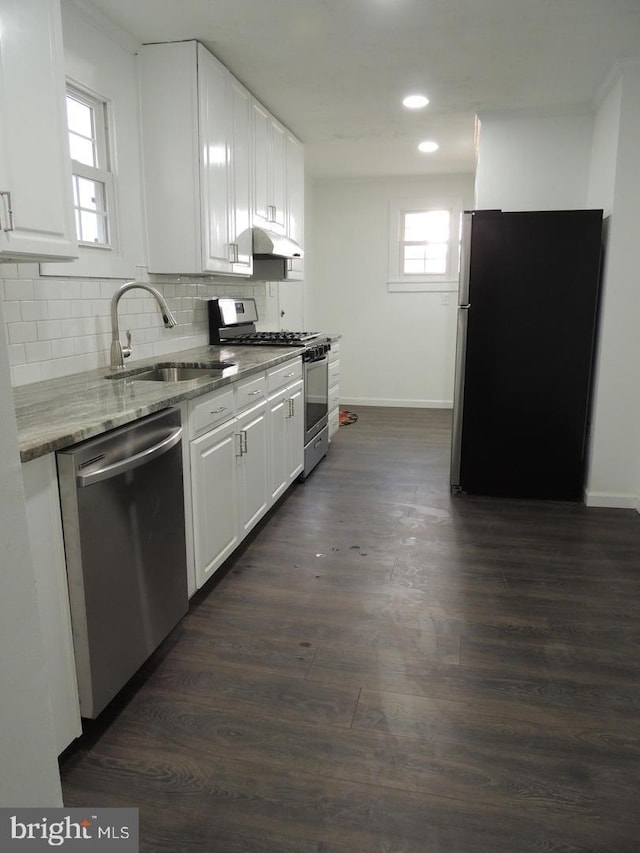 kitchen with dark wood-type flooring, appliances with stainless steel finishes, and white cabinetry