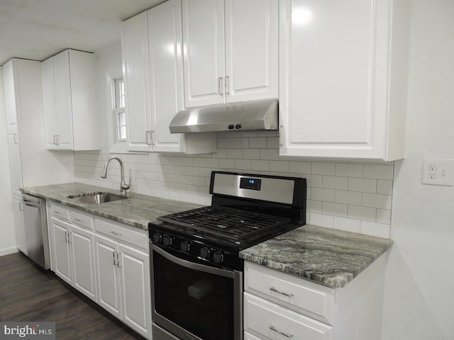 kitchen with white cabinets, light stone counters, dark wood-type flooring, sink, and stainless steel appliances