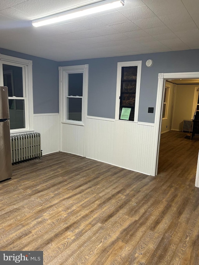 unfurnished room with dark wood-type flooring and radiator